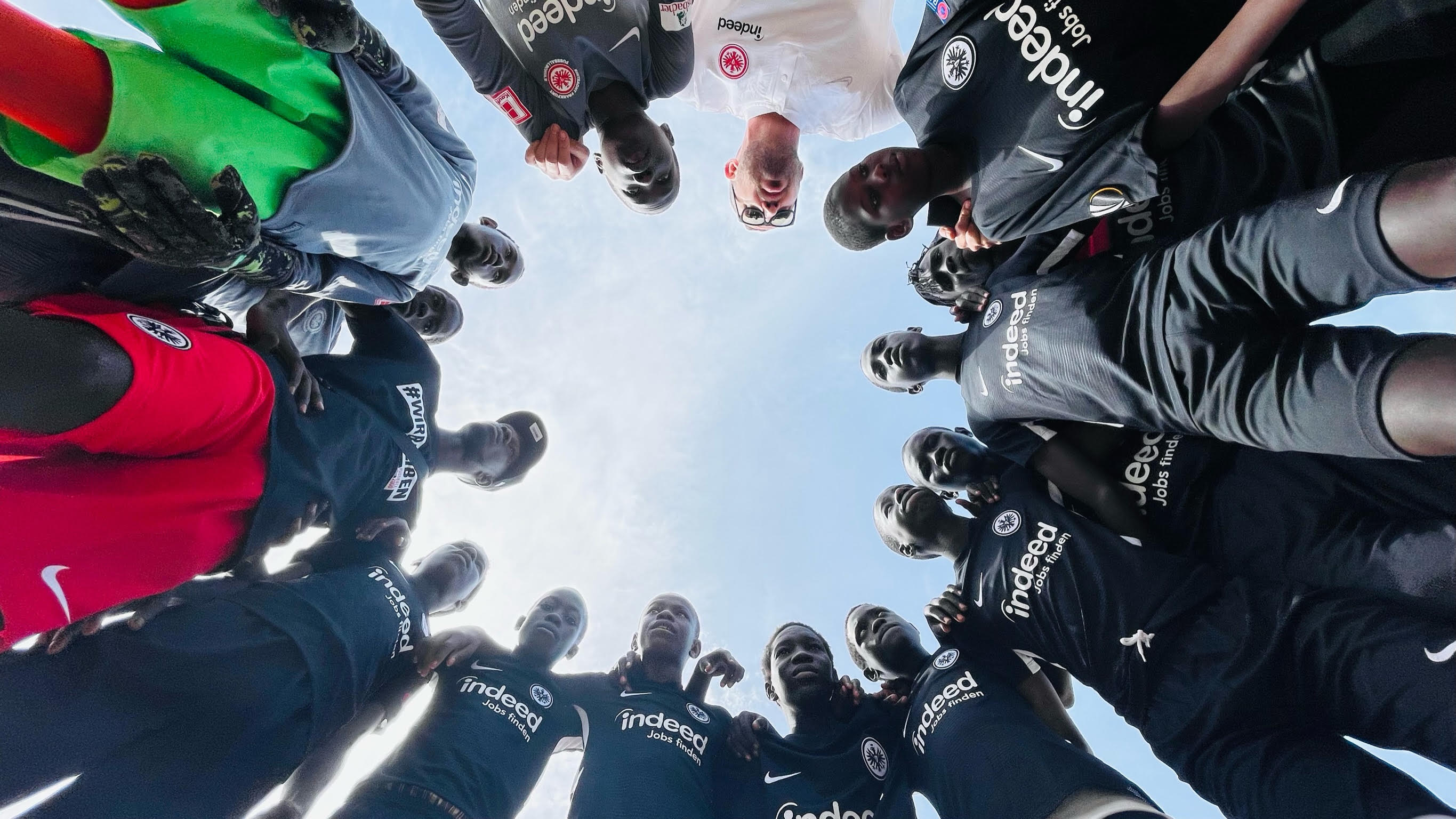 Spielerinnen und Spieler im Mannschaftskreis, von unten fotografiert
